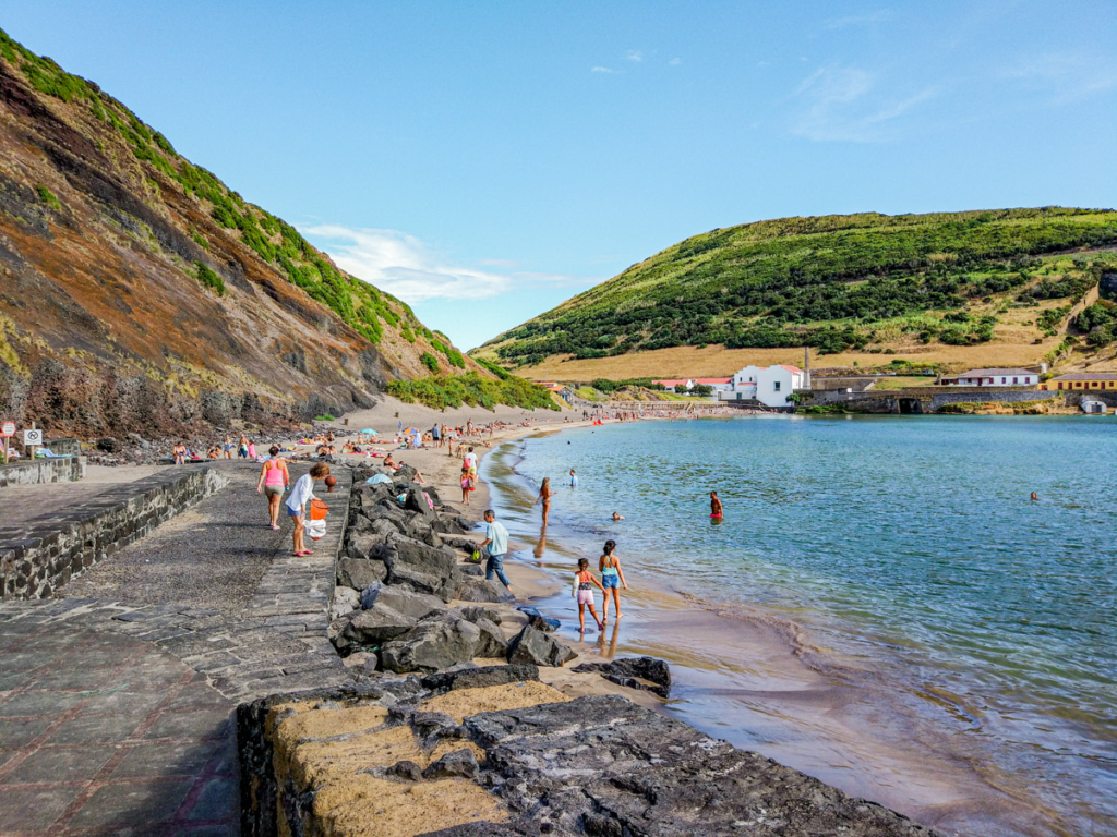 Baía da Praia de Porto Pim, com as suas águas calmas e areia escura.
