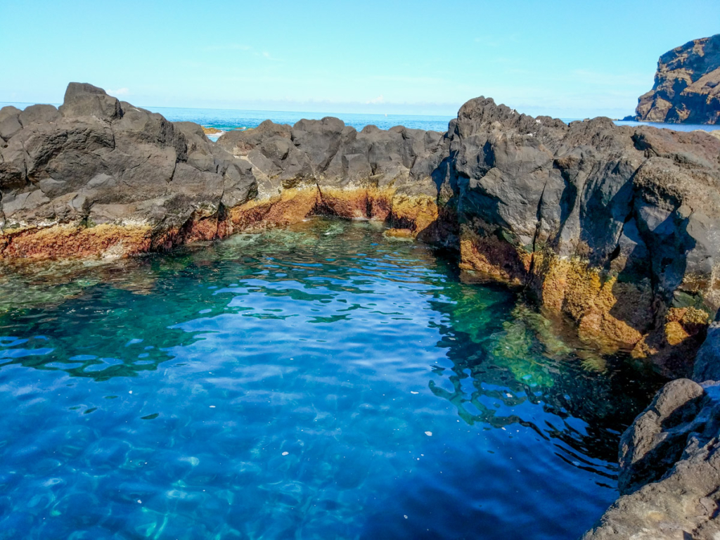 Piscinas naturais do Varadouro com a sua água azul e rodeadas por rocha vulcânica