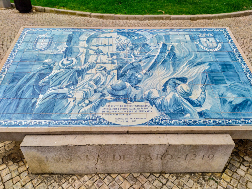 história da cidade de faro representada em azulejo frente às muralhas da cidade que circundam o centro histórico