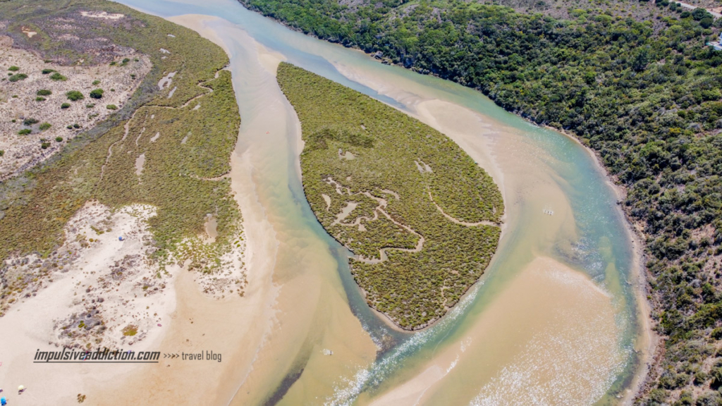Sapal da Ria de Aljezur na extremidade do areal. Existe uma ilha no centro da Ria