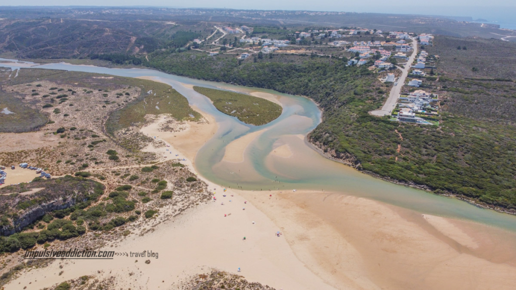 Vista aérea para o interior da praia da amoreira, onde se vê a ilha no centro da ria