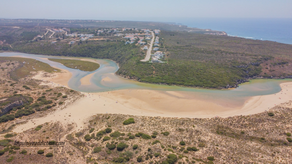 Vista aérea para o interior da praia da amoreira, onde se vê a ilha no centro da ria