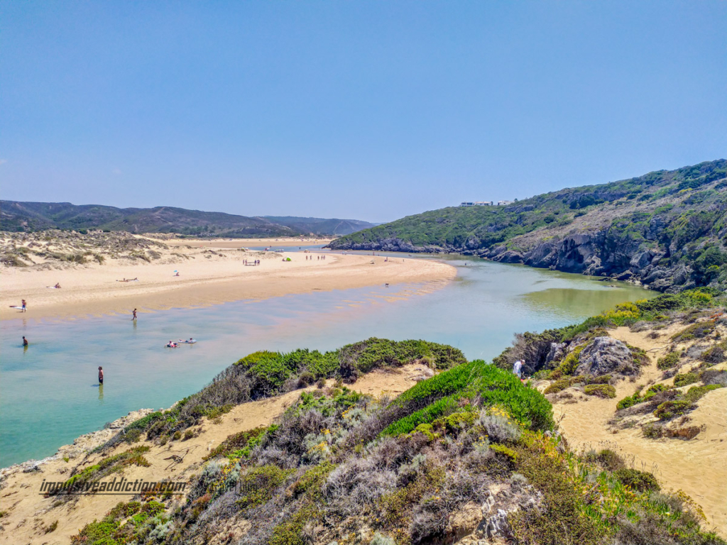 Curvas da Ria de Aljezur, junto à foz na praia da Amoreira. Pessoas aproveitam a praia do rio.