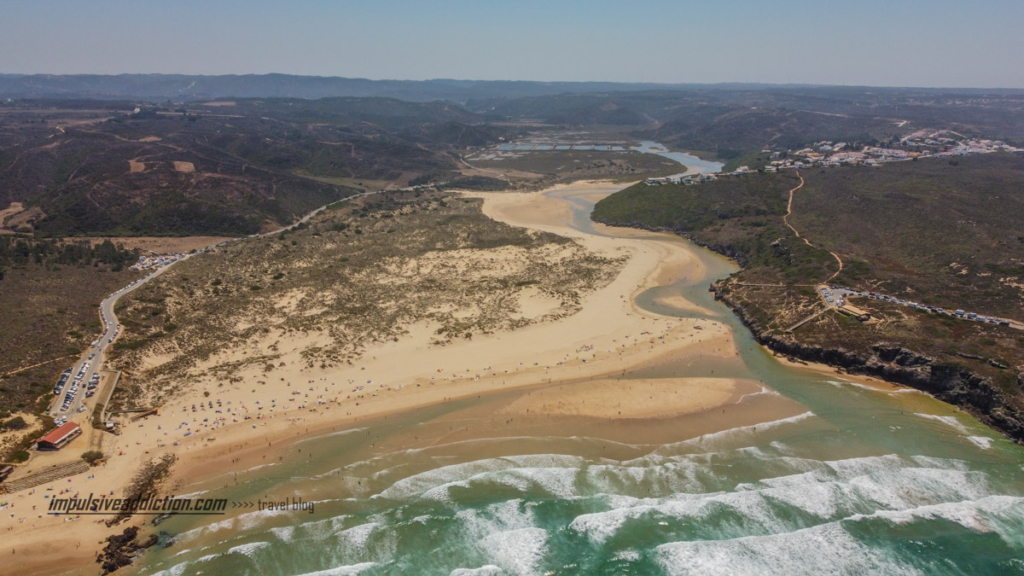Vista aérea frontal para a praia da Amoreira e Ria de Aljezur que serpenteia até ao mar