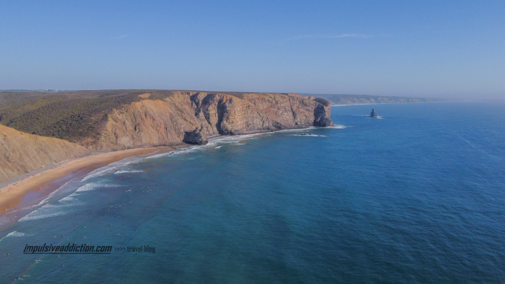 Praia da Arrifana com a pedra da agulha ao fundo, no mar.